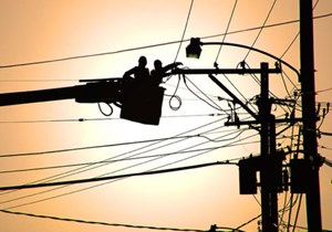 people working on an electric utility line in a cherry picker